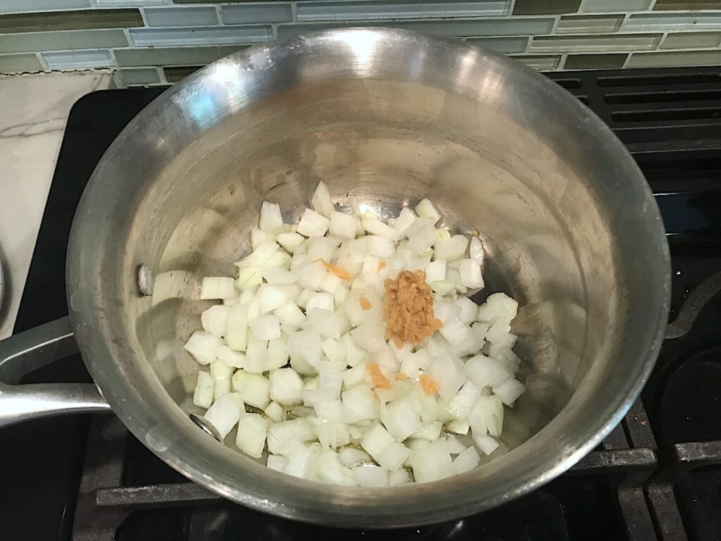 Raw onion and garlic in a pot for Brazilian Rice Recipe.