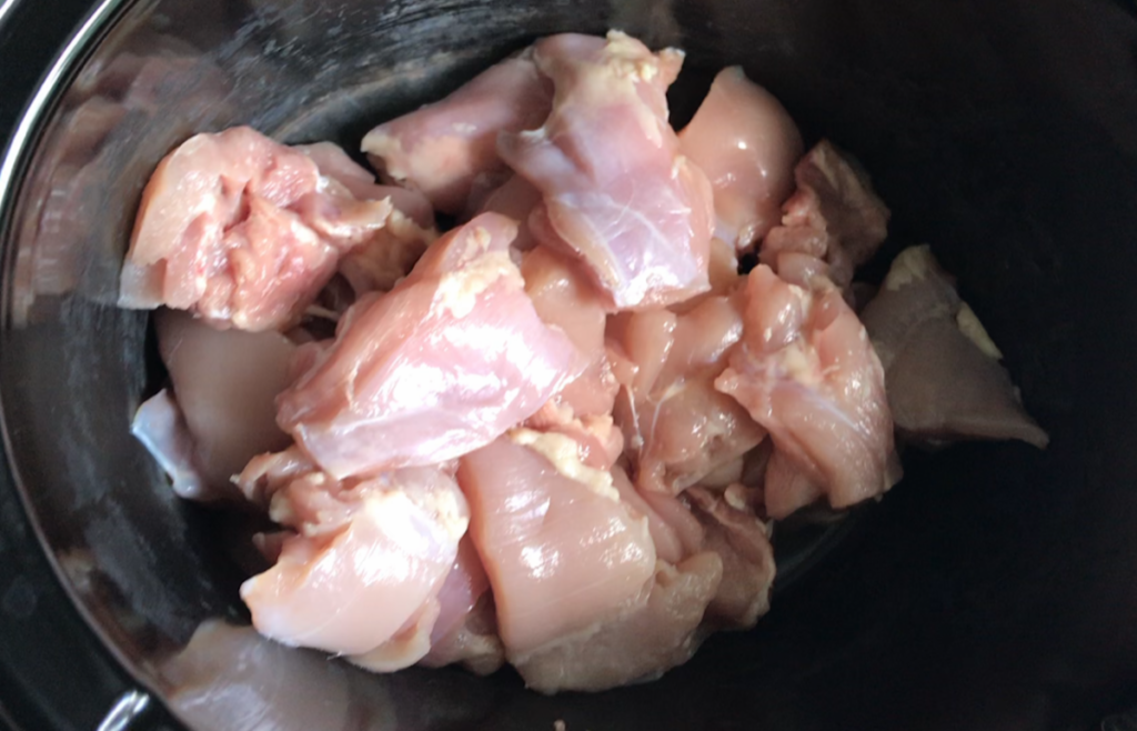 Cut chicken thighs in slow cooker for Brazilian Coconut Chicken stew.