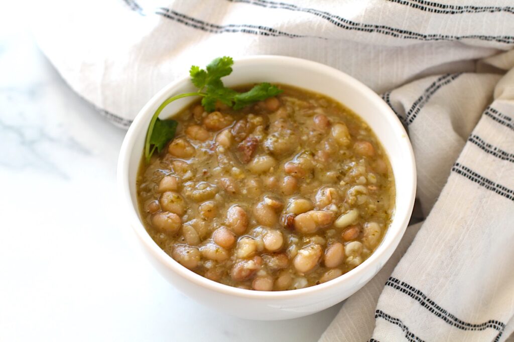 Carioca Beans in a bowl of beans with cilantro leaves on top.