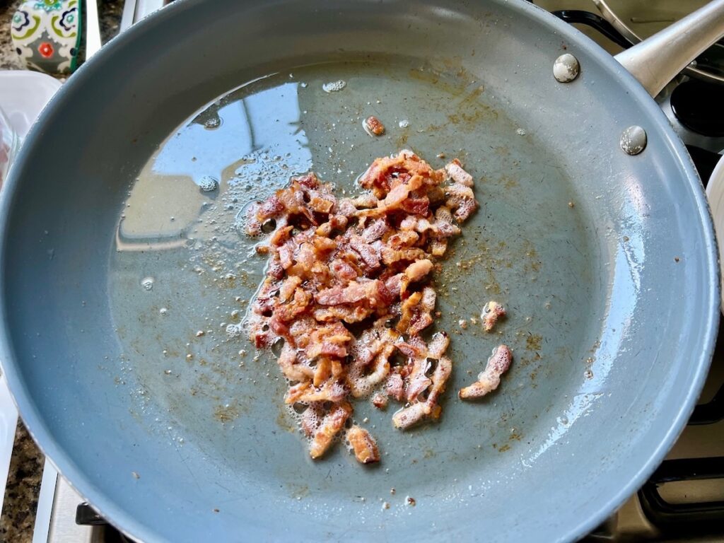 Cooked diced bacon in a pan for Brazilian Farofa Recipe.
