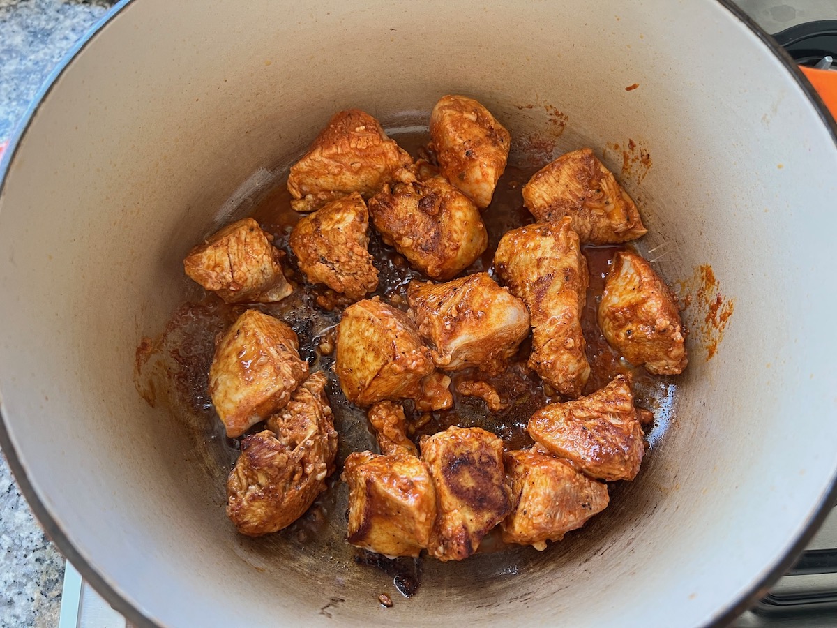 Marinated chicken cooking in a pot for Galinhada, Dutch Oven Chicken and Rice.