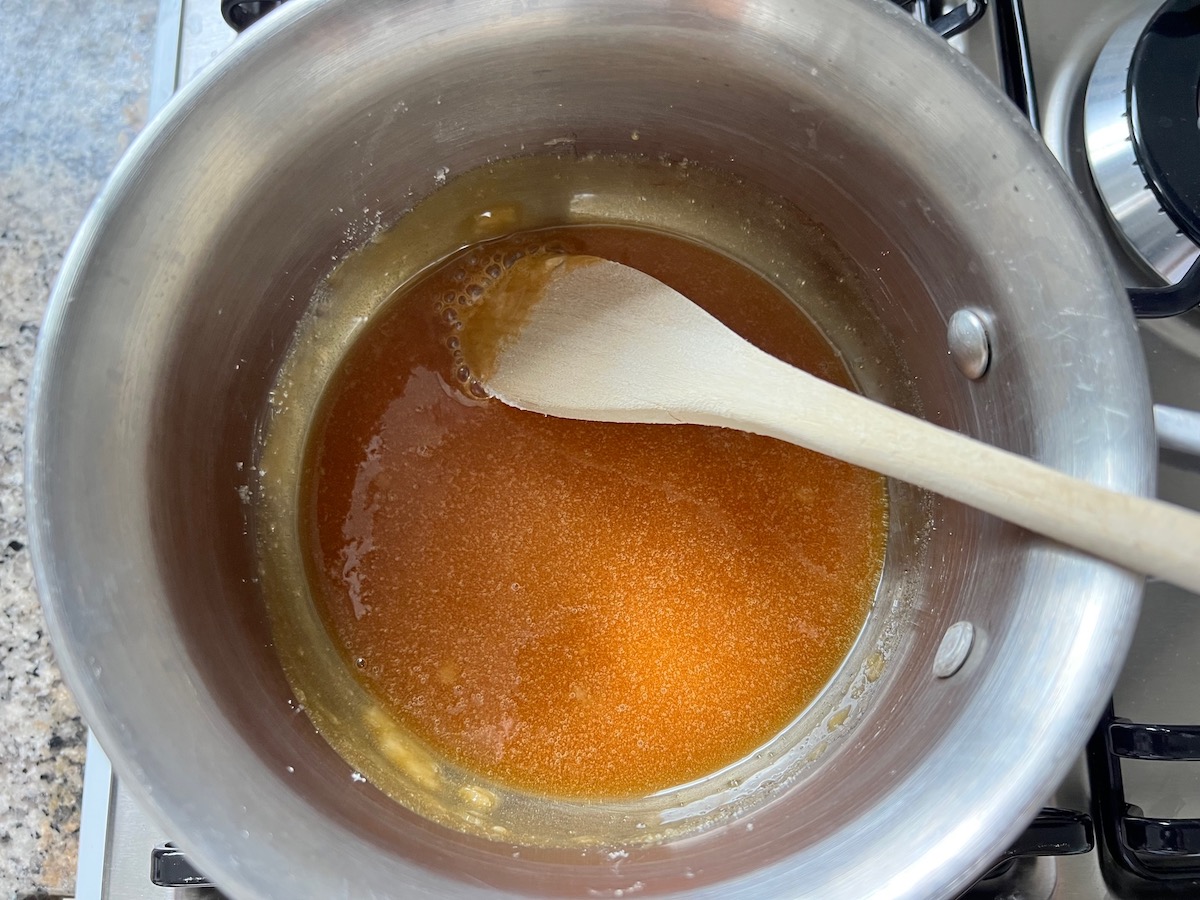 Granulated sugar completely melted into a deep amber color in a pot for Brazilian Flan Recipe, or Pudim.
