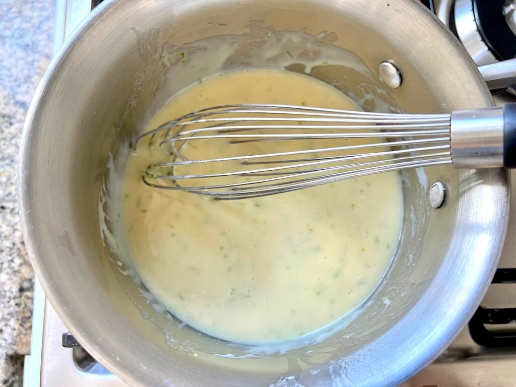 Lime glaze being whisked in a saucepan for Cake with Lime recipe.