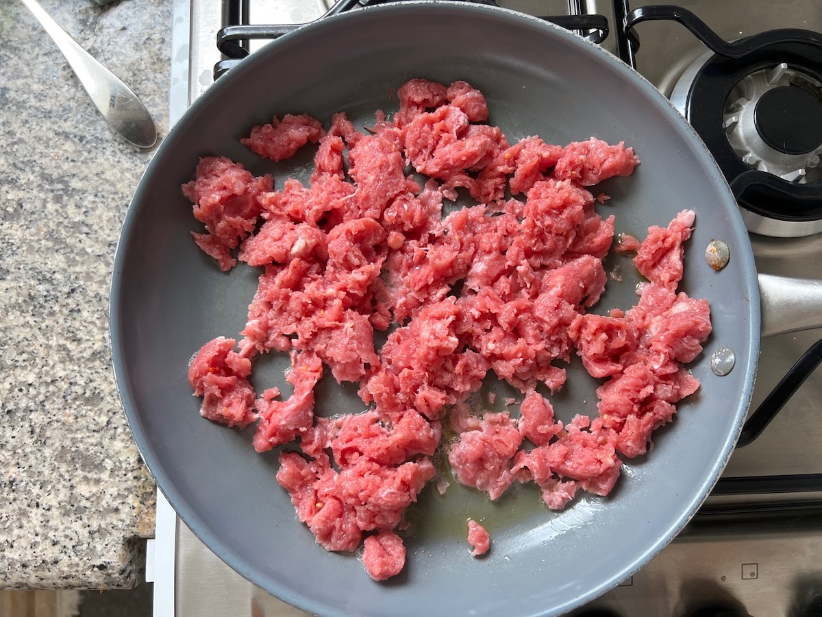 Pork sausage removed from the casings and in a pan being cooked for Spicy Sausage Pasta recipe.