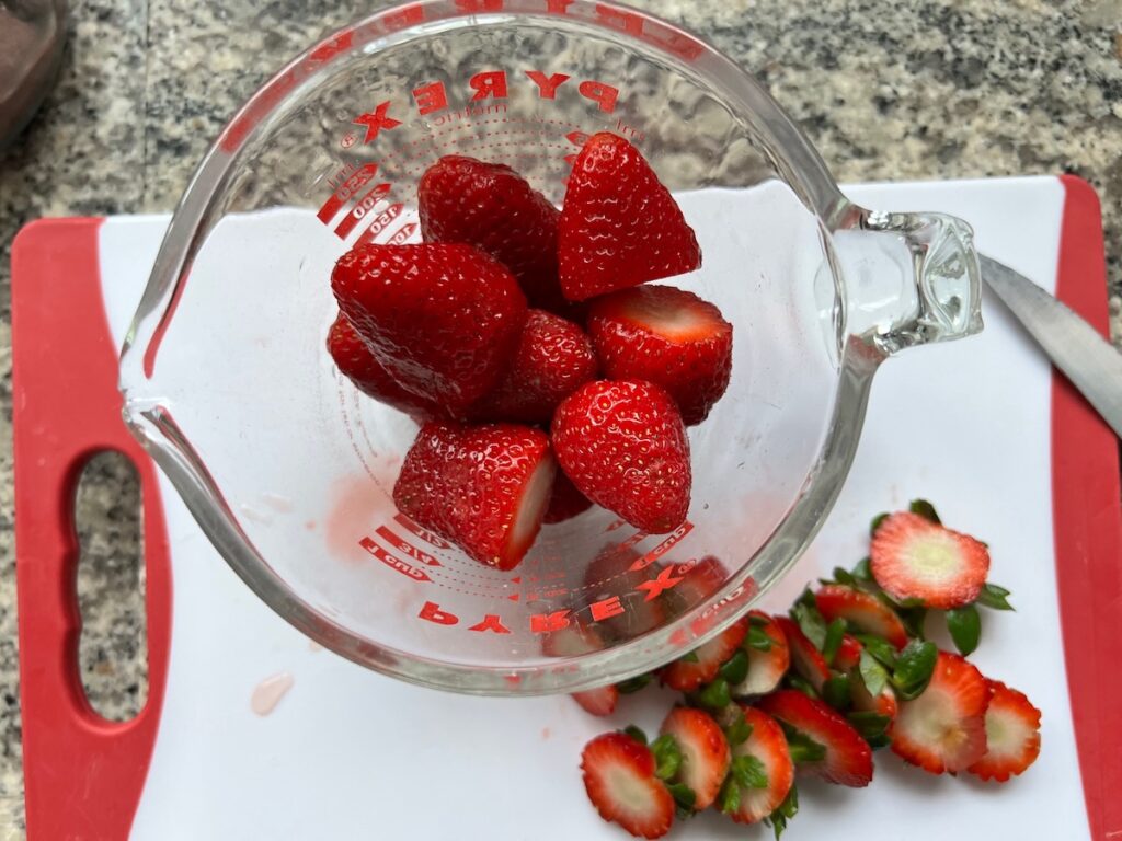 Strawberries in a bowl with the stems cut off for How to make Strawberry Acai Refresher.