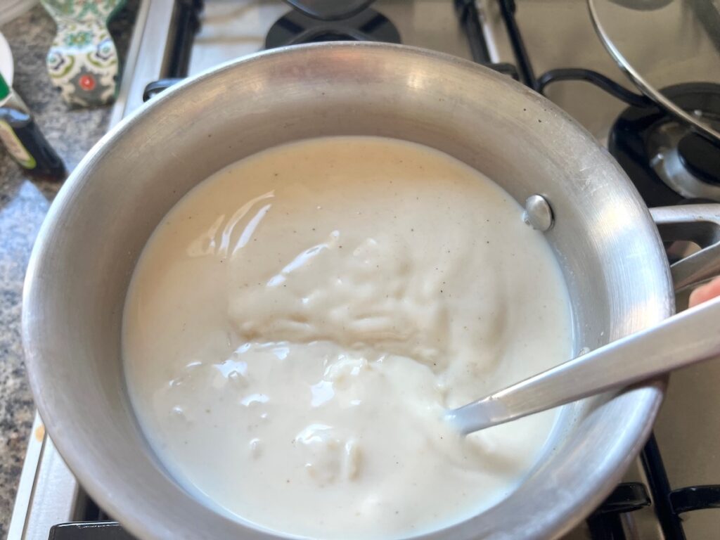 Spoon mixing all ingredients in a pot for Rice Pudding with condensed milk.