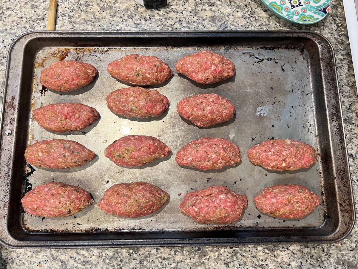 Raw Kibe on a sheet pan for Mediterranean Ground Beef Kabab recipe.