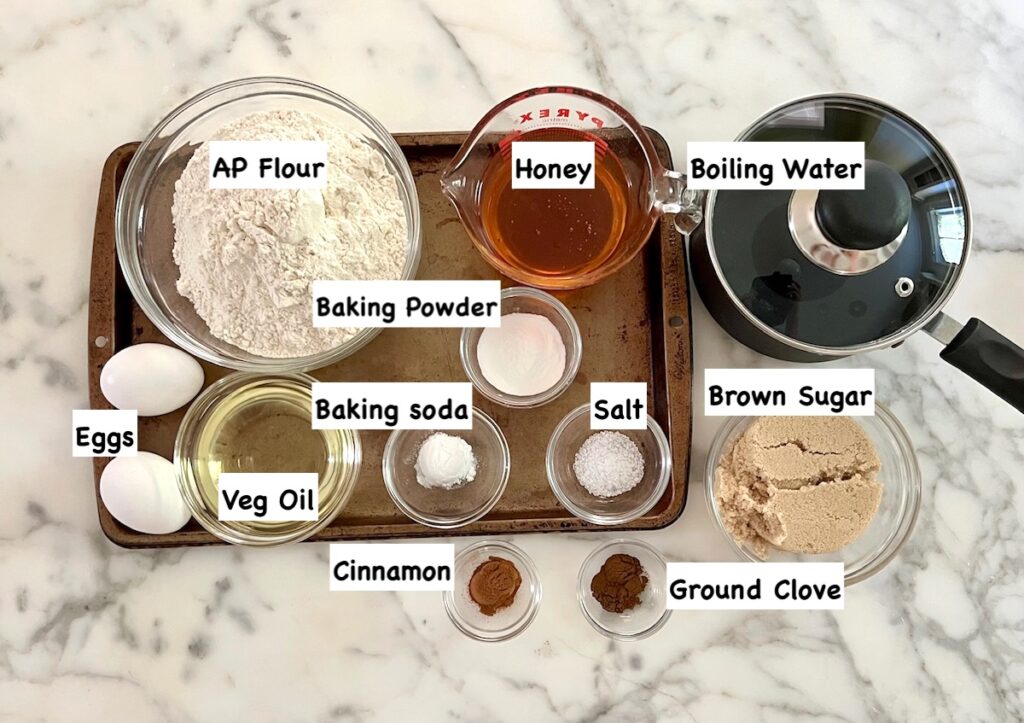 All ingredients for the cakes in bowls with labels for the recipe for Pao de Mel Brazilian cakes filled with dolce de leite and covered with chocolate.