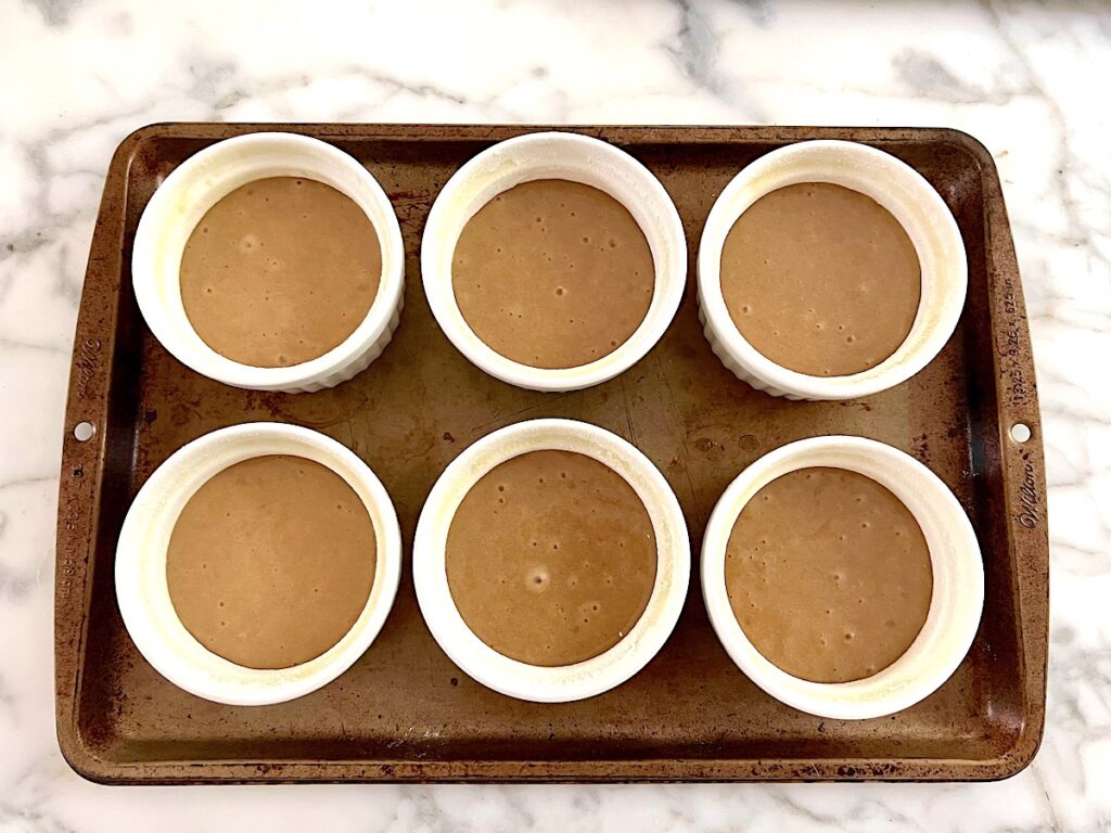 Batter poured into 6 (of the total 12) ramekins for the Pao de Mel recipe, Brazilian cakes filled with dolce de leite and covered with chocolate.