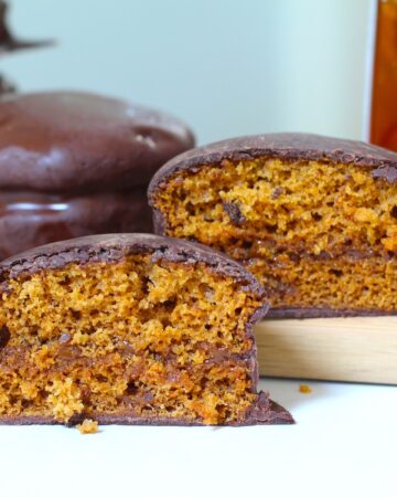 Pao de Mel Brazilian cakes filled with dolce de leite and covered with chocolate stacked with one cut in half and opened up facing forward.