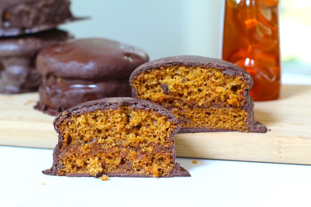 Pao de Mel Brazilian cakes filled with dolce de leite and covered with chocolate stacked with one cut in half and opened up facing forward.
