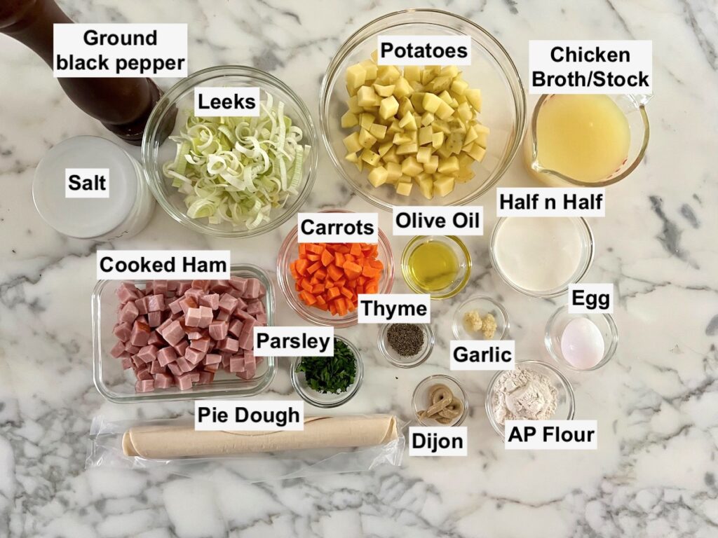 All ingredients measure out in bowls on counter and labeled for this Ham and Leek Pie recipe.