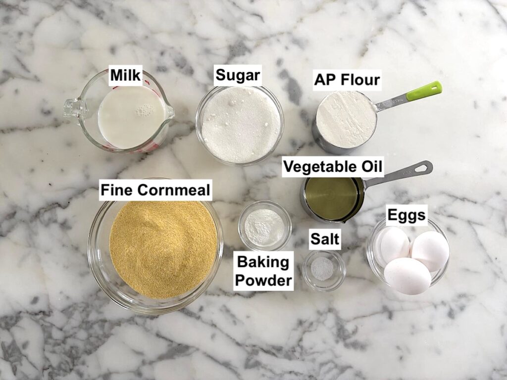 Ingredients for Bolo de Fuba, Cornmeal Cake, recipe measured out into bowls on counter.